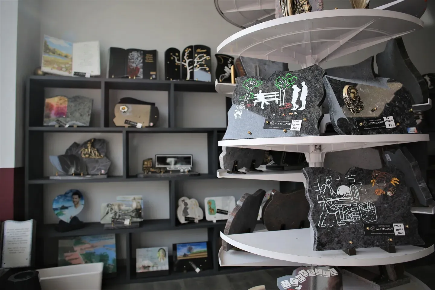 Présentoirs de plaques funéraires gravées dans un magasin de pompes funèbres.