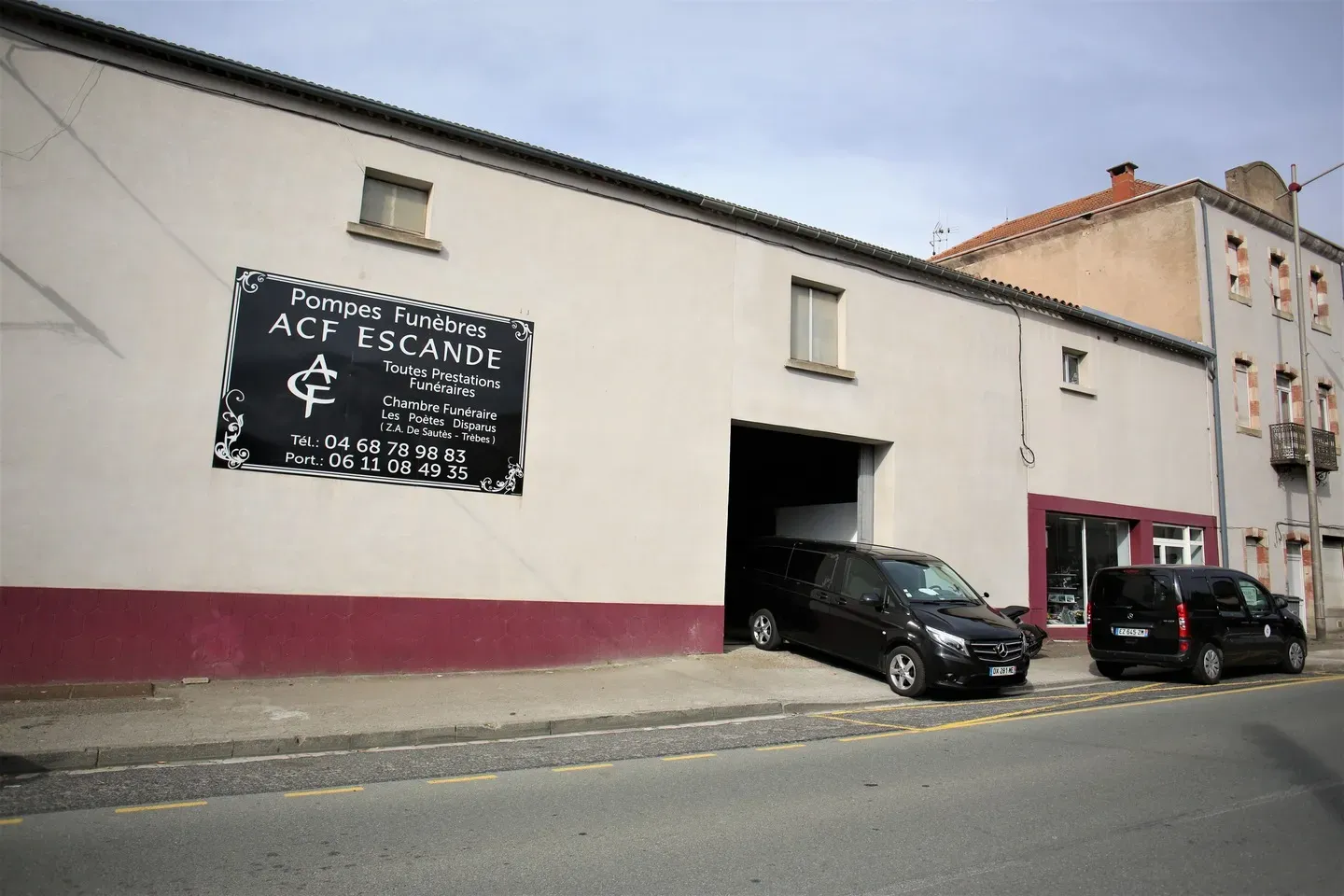 Bâtiment des Pompes Funèbres ACF Escande avec deux fourgons noirs garés.