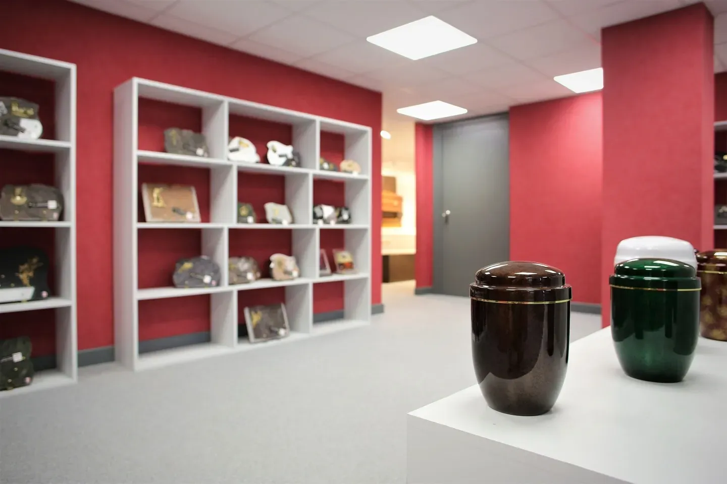 Urnes funéraires modernes exposées en premier plan dans un magasin spécialisé.