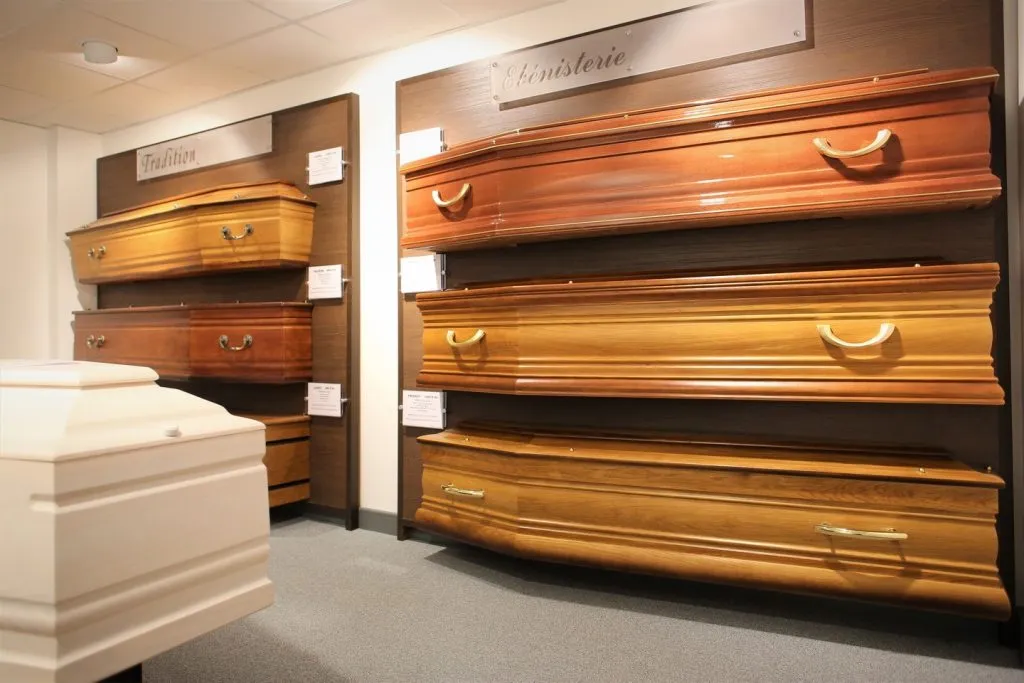 Exposition de cercueils en bois verni des gammes Tradition et Ébénisterie.