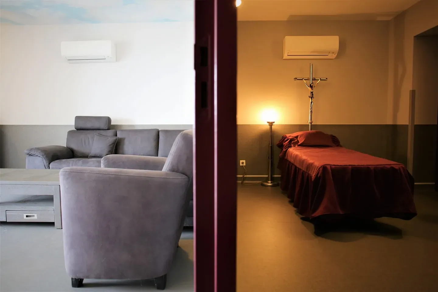 Chambre funéraire avec salon d'accueil et espace de recueillement avec crucifix.